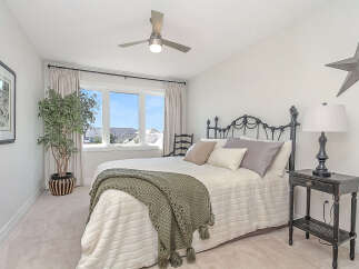 This charming bedroom features a comfortable queen-size bed with a plush duvet and a decorative knit throw, perfect for relaxation.