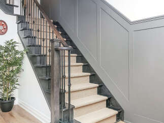 Experience elegance with this stunning staircase, featuring dark wood treads and risers complemented by a neutral carpet runner.