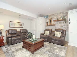 Experience ultimate relaxation in this cozy basement living area, featuring plush leather recliners perfect for movie nights.