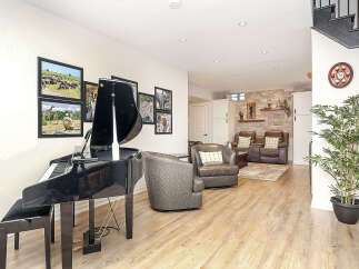 Experience luxury living in this stunning home featuring a grand piano for musical evenings and a cozy seating area with plush leather chairs.