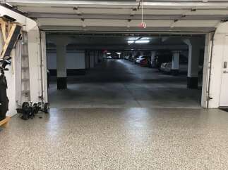 Discover this spacious garage with a durable, speckled epoxy floor, perfect for protecting your vehicles.