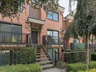 Discover modern urban living in this stunning brick townhouse, featuring a welcoming entrance with a covered porch and a private balcony perfect for enjoying your morning coffee.