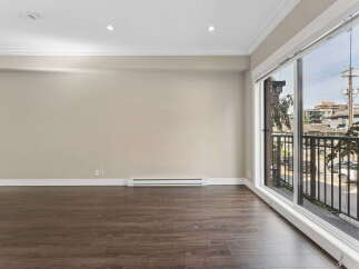 Experience modern living in this spacious room featuring elegant crown molding and recessed lighting.