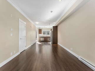 Step into this bright and airy living space featuring rich hardwood floors and elegant crown molding.