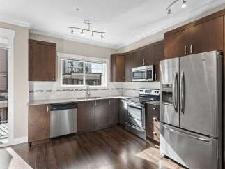 Discover this modern kitchen featuring sleek stainless steel appliances, including a refrigerator, dishwasher, and microwave.