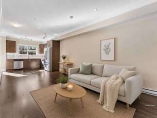 Experience modern living in this beautifully staged open-concept space, featuring a sleek kitchen with stainless steel appliances and rich wood cabinetry.