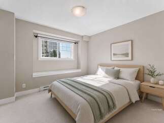 Discover comfort and style in this beautifully staged bedroom, featuring a plush queen-size bed adorned with soft, neutral linens and a cozy green throw.