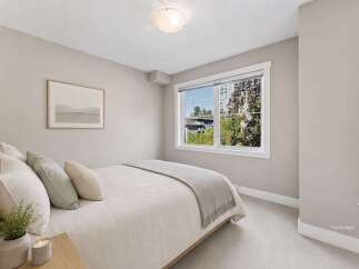 Discover comfort and style in this beautifully staged bedroom, featuring a plush queen-sized bed adorned with soft, neutral-toned linens and accent pillows.
