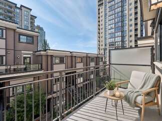 Enjoy your morning coffee or evening relaxation on this charming balcony, complete with a comfortable chair, a small side table, and a potted plant.