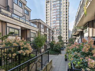 Discover modern urban living in this stunning townhouse complex, featuring a striking high-rise backdrop.