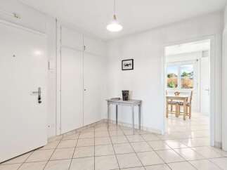 Discover this charming entryway featuring a large white door with a modern handle and keys.