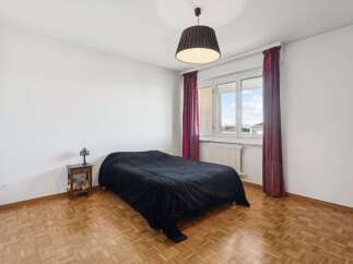 This cozy bedroom features a comfortable bed with a plush black comforter, perfect for a restful night's sleep.
