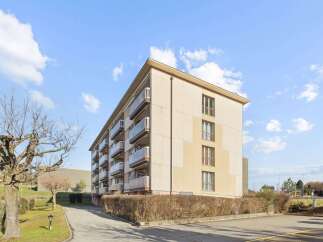 Discover this charming apartment building featuring multiple balconies with glass railings, offering residents ample outdoor space and natural light.
