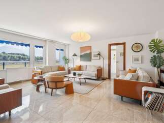 Experience modern living in this spacious living room, featuring a comfortable sectional sofa and elegant accent chairs.