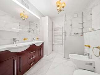 Experience modern luxury in this stunning bathroom featuring a double vanity with a rich, dark wood cabinet and sleek chrome fixtures.