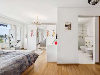 This spacious bedroom offers a comfortable retreat with a large bed featuring a patterned duvet.