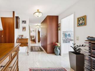 Step into this elegant hallway featuring a beautiful wooden secretary desk and ample built-in storage.