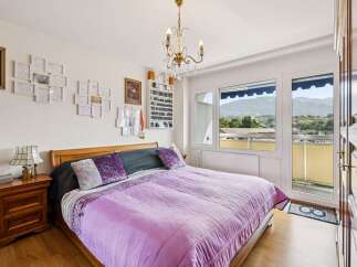 Experience comfort and style in this beautifully appointed bedroom, featuring a plush purple comforter and elegant decorative pillows.