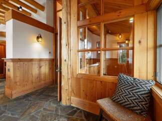 Experience rustic charm in this inviting entryway featuring warm wood paneling and exposed beams.