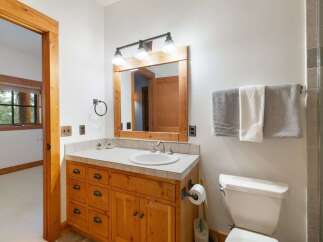 This bathroom features a charming wooden vanity with ample drawer storage and a tiled countertop.