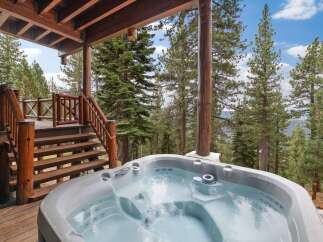 Experience ultimate relaxation in this luxurious hot tub, perfectly situated on a rustic wooden deck with stunning forest views.