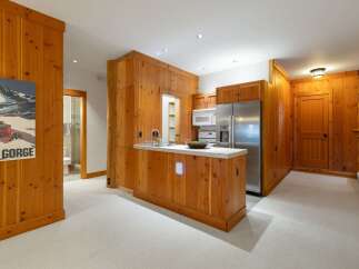 Experience rustic charm in this cozy kitchen featuring warm wood paneling throughout.