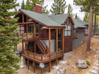 Experience rustic charm and modern comfort in this stunning log-style home, nestled amidst towering pine trees.