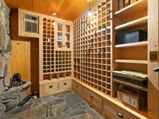 Discover this exceptional wine cellar, featuring extensive wooden racks designed to store a vast collection of wines.