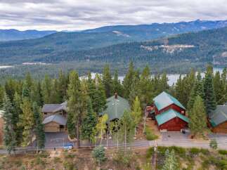 Nestled amidst towering pine trees, this stunning property offers breathtaking lake and mountain views.