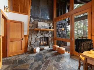 Experience rustic charm in this inviting living space, featuring a grand stone fireplace as the centerpiece.
