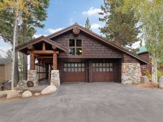 Experience rustic charm with this stunning mountain home, featuring a grand log-accented entrance and a natural stone facade.