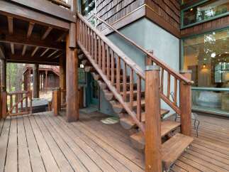 Experience rustic charm with this stunning log cabin exterior, featuring a beautiful wooden deck and a grand staircase leading to the entrance.