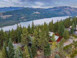 Nestled amidst towering pine trees with a breathtaking lake and mountain view, this property offers a serene escape.