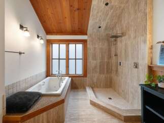 Experience ultimate relaxation in this luxurious bathroom featuring a deep soaking tub and a spacious walk-in shower with a rainfall showerhead.