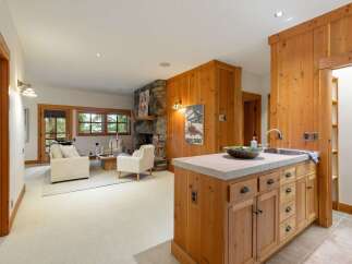 Experience rustic charm in this inviting living space, featuring a natural stone fireplace and warm wood paneling.