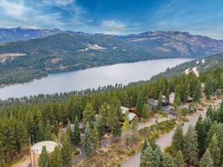 Experience breathtaking lake and mountain views from this stunning property nestled among tall pine trees.