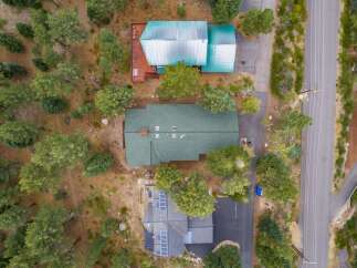 Discover this stunning property featuring multiple homes nestled amongst mature trees.