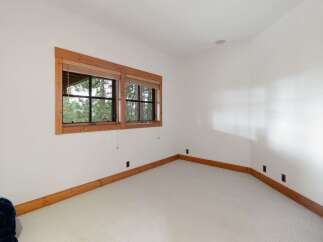 This room features a large window with wooden trim, offering a view of the surrounding trees.