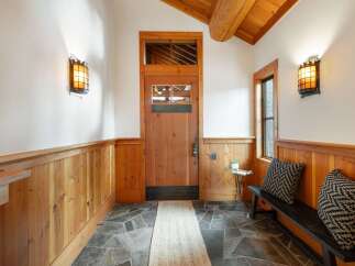 Step into this charming entryway featuring a rustic wooden door and warm wood paneling, creating an inviting atmosphere.