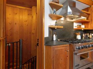 Experience rustic charm in this kitchen featuring warm wood paneling and cabinetry.