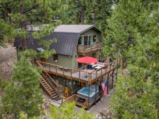 Experience mountain living in this charming home nestled among tall pine trees.