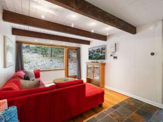 Experience cozy living in this charming living room, featuring a vibrant red sectional sofa perfect for relaxation.