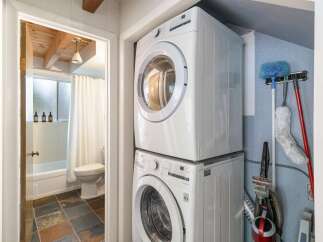 Discover the convenience of this compact laundry area, featuring a stacked washer and dryer.