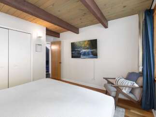 Experience cozy living in this charming bedroom featuring a comfortable bed and a wall-mounted TV for entertainment.