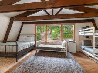 Experience rustic charm and ample sleeping space in this unique cabin bedroom.