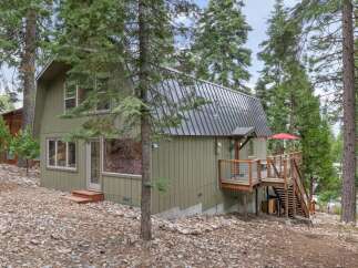 Nestled among tall pine trees, this charming home offers a serene mountain retreat.