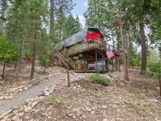 Escape to this charming cabin nestled among tall pine trees, offering a serene mountain retreat.