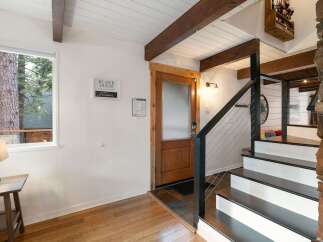 Step into this charming entryway featuring a warm wooden door and a striking stone fireplace.