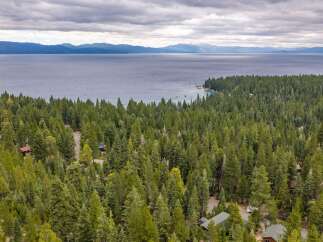 Experience the serene beauty of Lake Tahoe from this stunning property nestled amidst a lush pine forest.