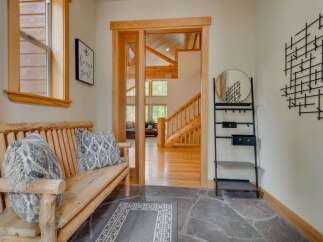 Step into a warm and inviting entryway featuring a rustic log bench with decorative pillows, perfect for a cozy welcome.
